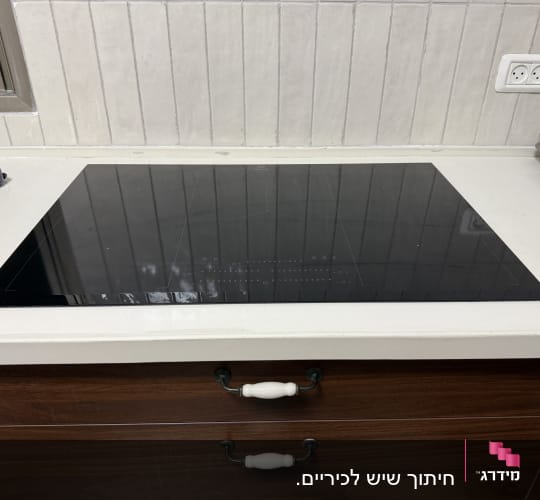 משטח שיש לבן עם כיריים שחורות מובנות